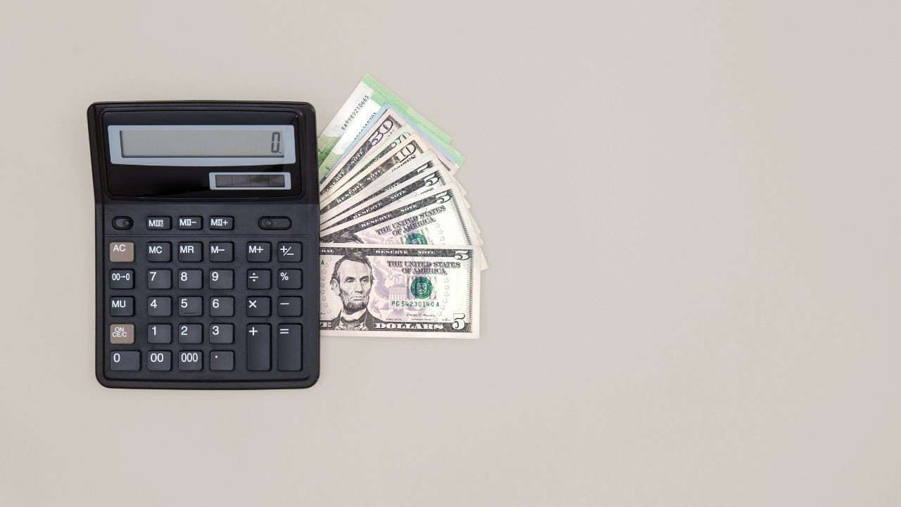 hesap makinesi arkasında bulunan dolar banknotları